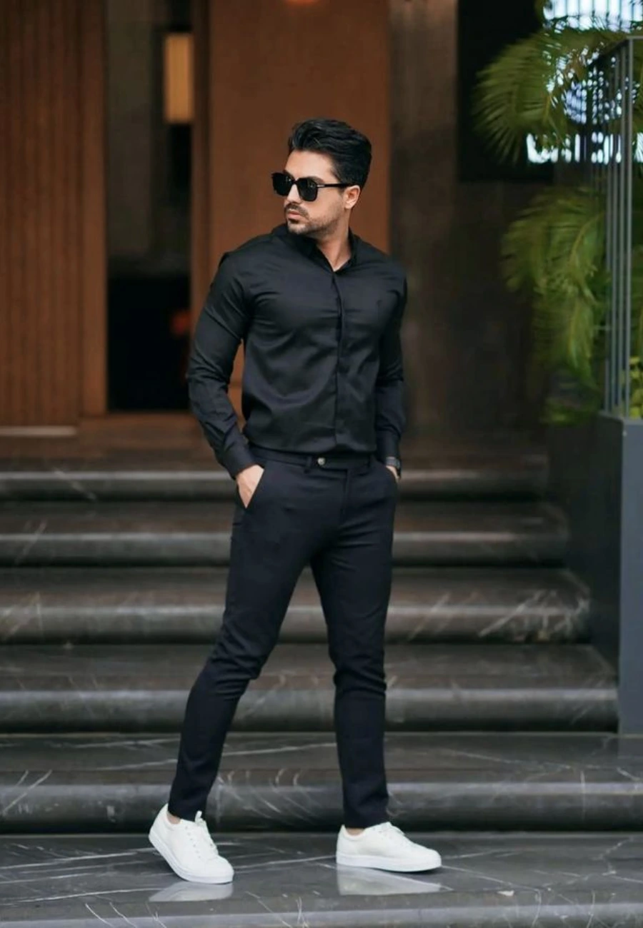 Man in all-black outfit with white sneakers.