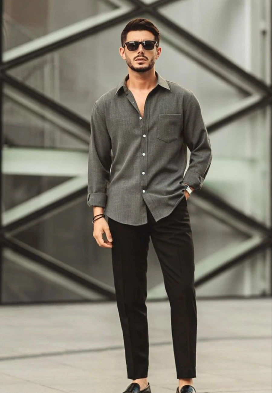Man wearing grey shirt black trousers