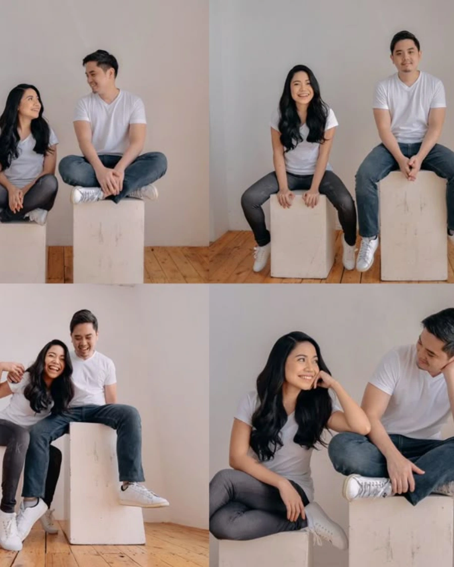Couple sitting and smiling in casual outfits.
