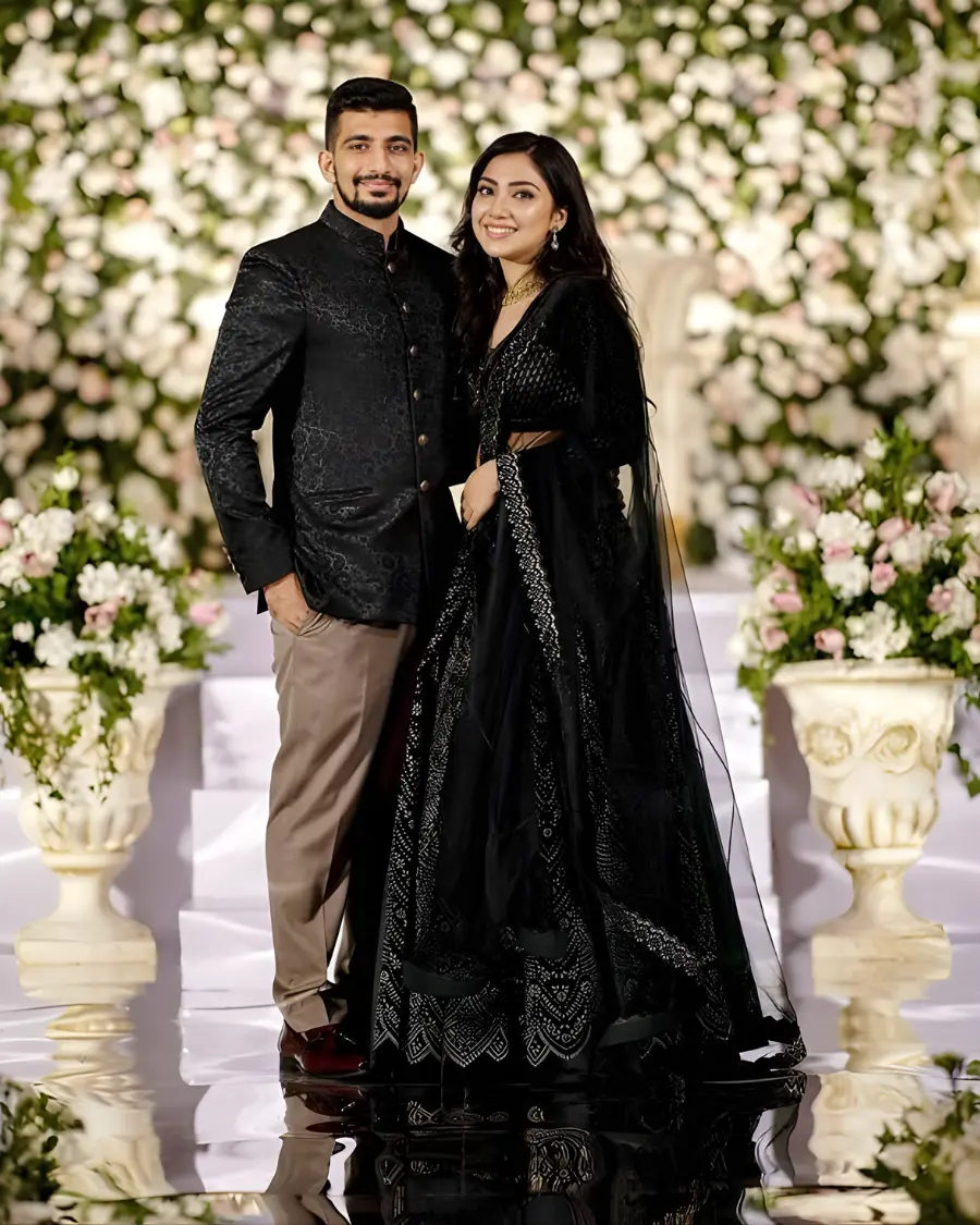 Couple in black formal wear at a wedding ceremony.
