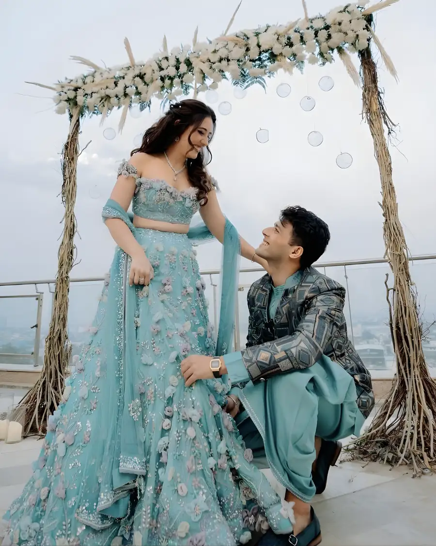 Couple posing in blue wedding outfits.