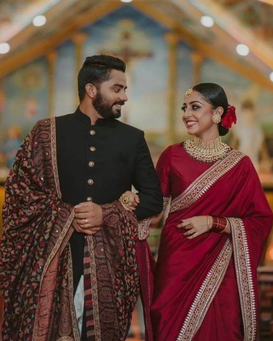Couple in red saree and black sherwani.