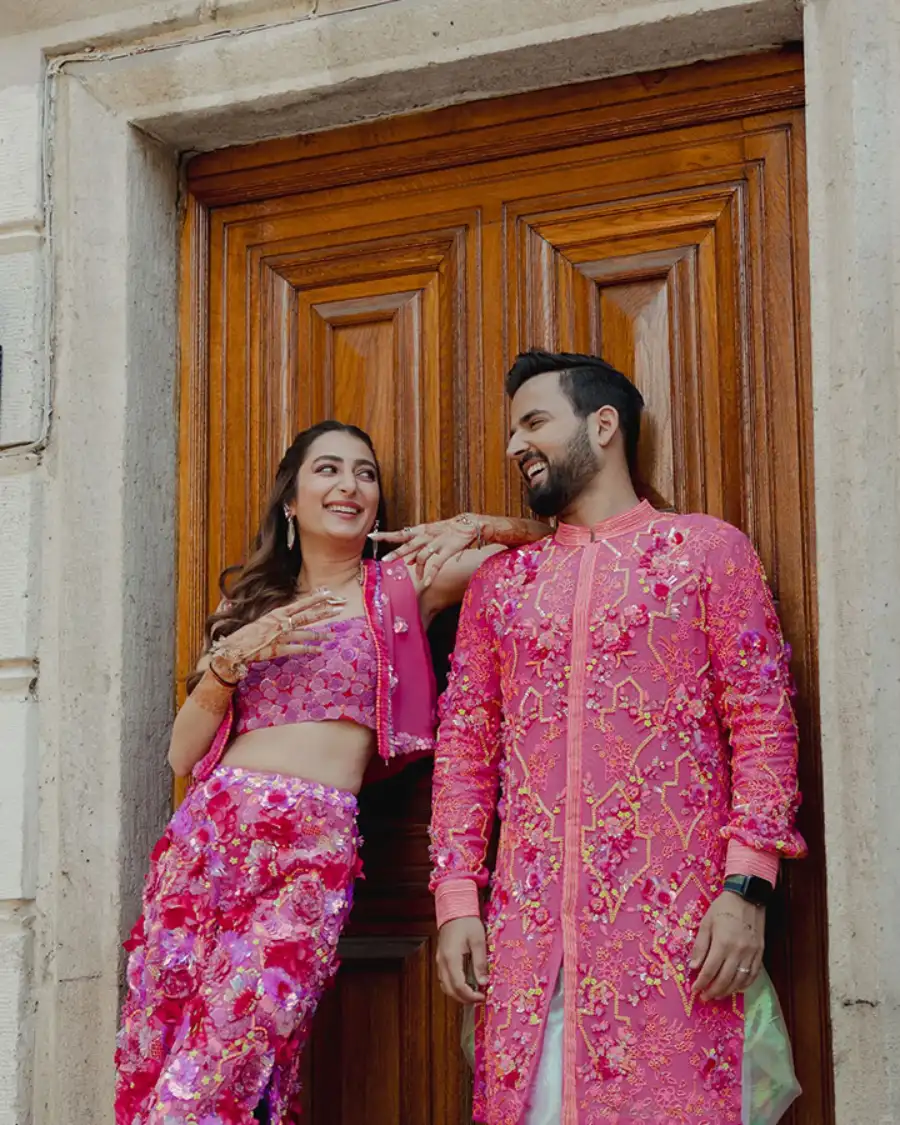 Couple in pink traditional wedding outfits.