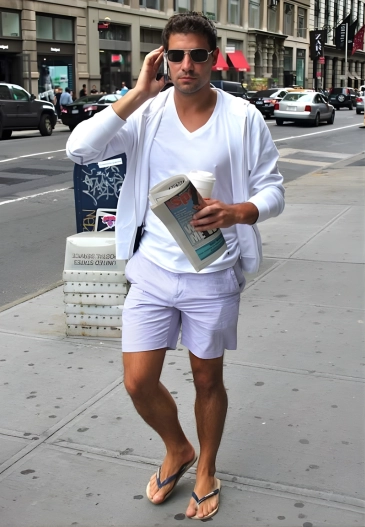 Man in white hoodie, shorts, and flip-flops